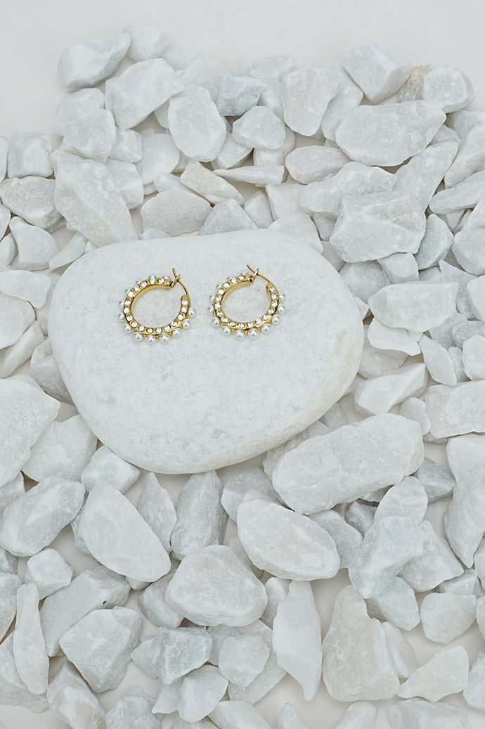 Small full hoop earrings with a pearl-style bead in gold tone