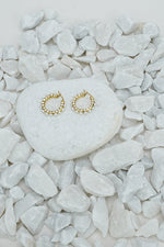 Small full hoop earrings with a pearl-style bead in gold tone