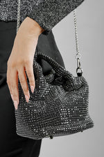 Woman wearing the Stellar black crystal bucket bag crossbody with chain strap, front view