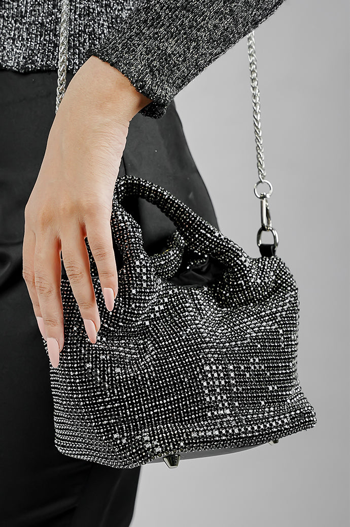 Woman wearing the Stellar black crystal bucket bag crossbody with chain strap, front view
