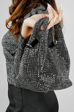 Stellar black crystal bucket bag held in hand, close view
