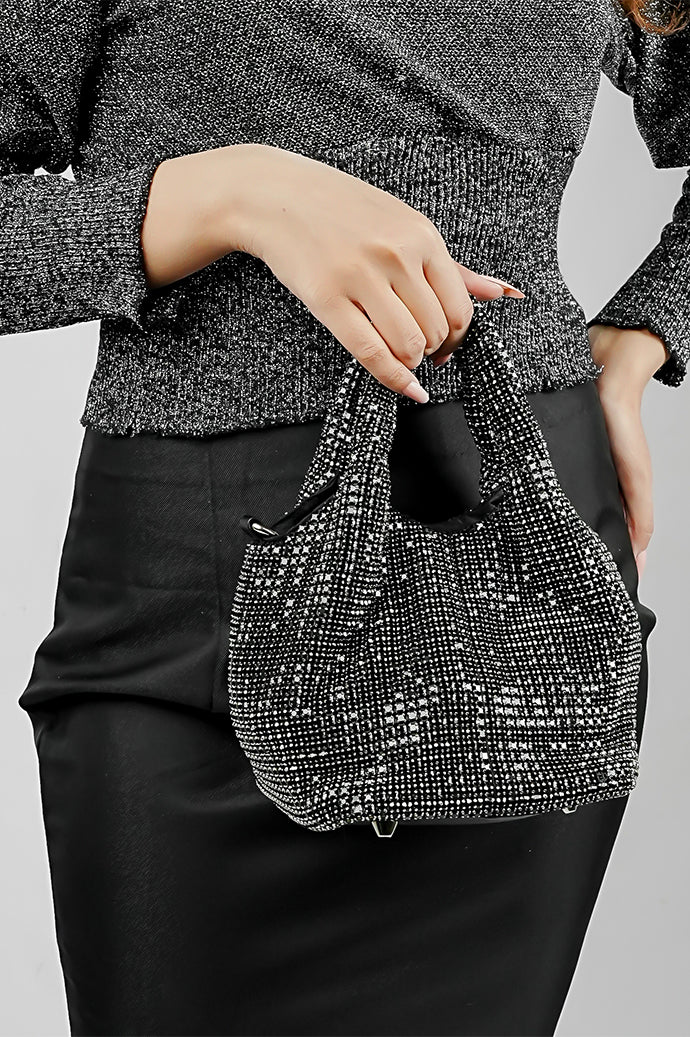 Stellar black crystal bucket bag held by the handles with a black skirt