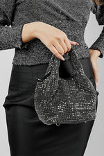 Stellar black crystal bucket bag held by the handles with a black skirt