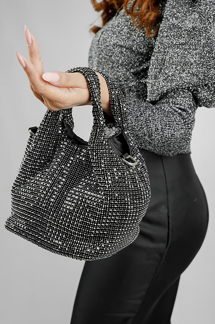 Black crystal bucket bag carried on the arm by its top handles
