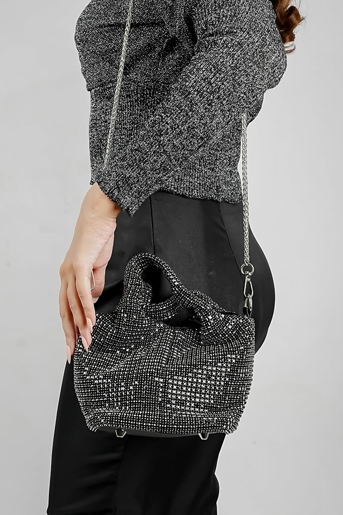 Black crystal bucket bag with chain strap worn over the shoulder with a black outfit