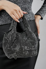 Woman carrying the Stellar black crystal bucket bag by its top handles