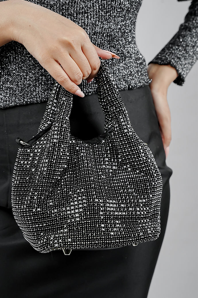 Woman carrying the Stellar black crystal bucket bag by its top handles