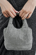 Stellar silver crystal bucket bag held by the handles, front view