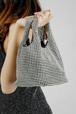 Stellar silver crystal bucket bag hanging from the arm