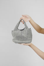 Stellar silver crystal bucket bag hanging from the arm