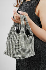 Woman carrying the Stellar silver crystal bucket bag at her side