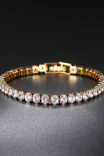 Gold-tone tennis bracelet for women with a row of clear round stones and a fold-over clasp, Future Style