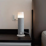 Textured Tower aroma diffuser with warm glow light on a dark bedside table beside a wall socket