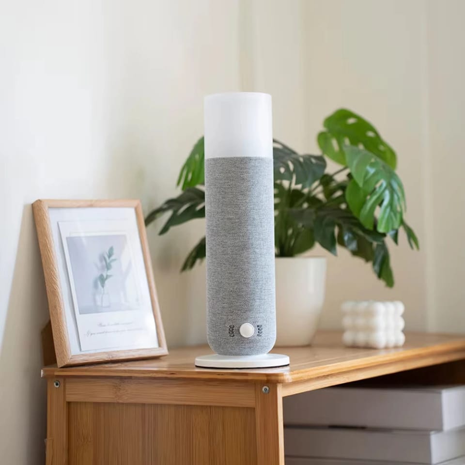 Grey Textured Tower aroma diffuser with warm glow light on a wooden side table beside a plant, Future Life Style Pakistan