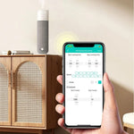 Phone showing the Textured Tower aroma diffuser app on a cabinet in a living room