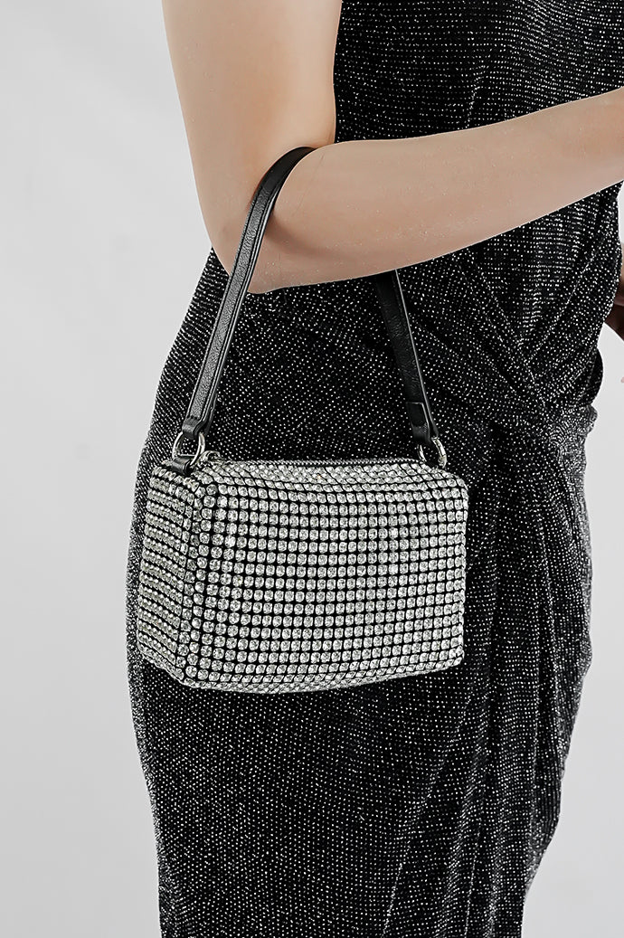 Woman holding the Wang Large silver bag by its strap in front of a black dress