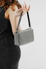 Woman carrying the Wang Large silver bag over her arm, seen from the side