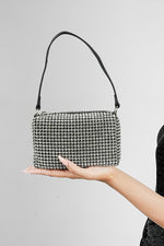 Wang Large silver rectangle bag with black strap held up on a grey background