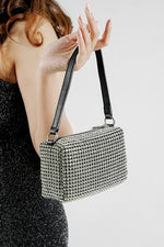 Wang Large silver bag with black strap worn on the shoulder, side view