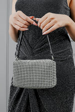 Woman holding the Wang Large silver bag by the strap with both hands