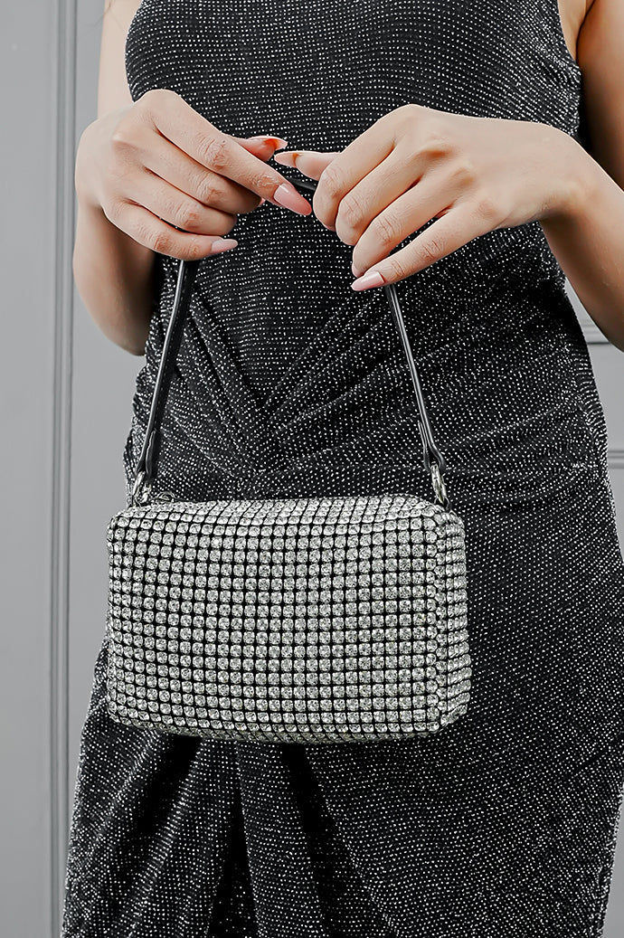 Woman holding the Wang Large silver bag by the strap with both hands